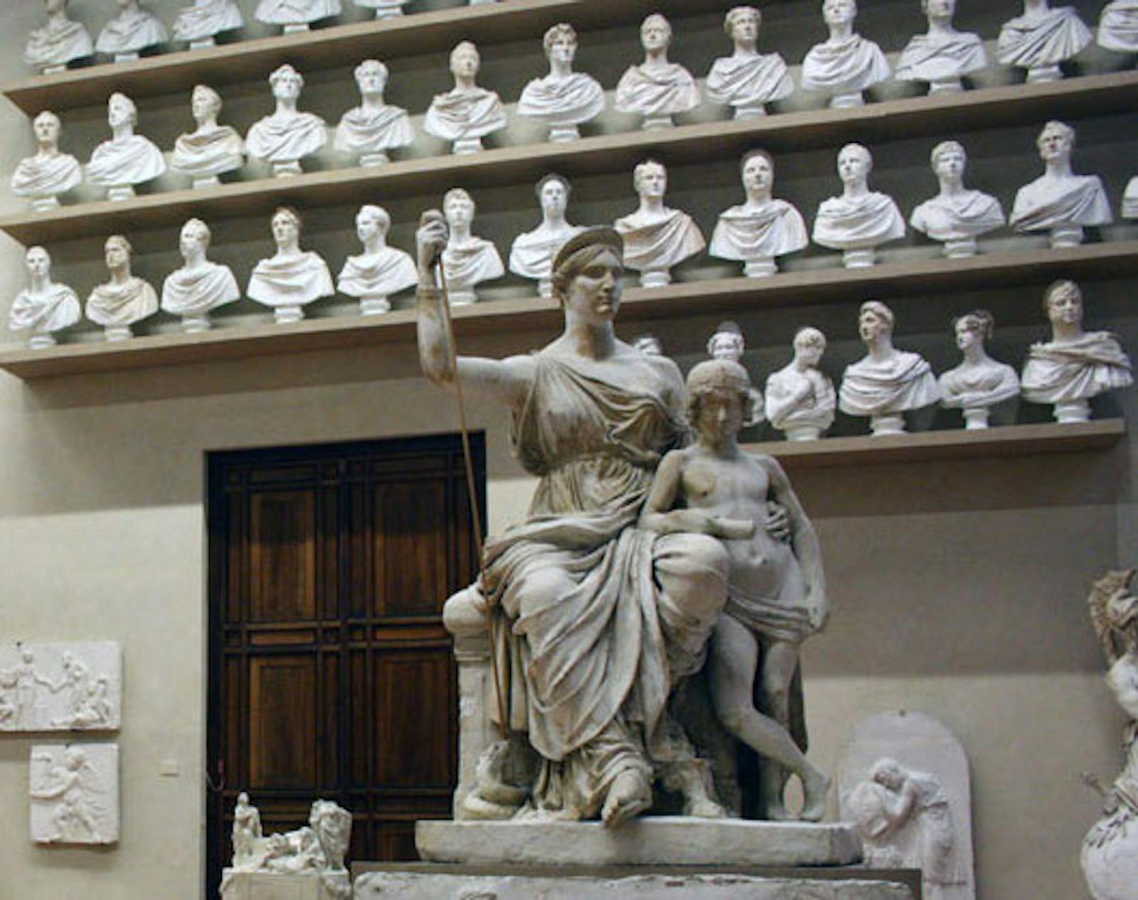 Statua della Galleria dell'Accademia davanti a dei busti